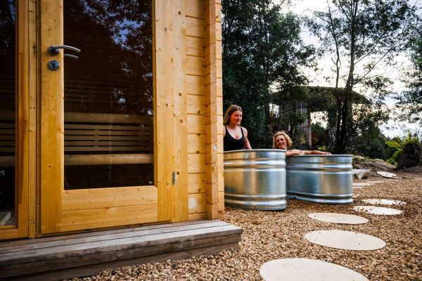 Maydena Wilderness Wellness Sauna and Cold plunge couple in cold plunge ice bath next to wood fired sauna at maydena bike park